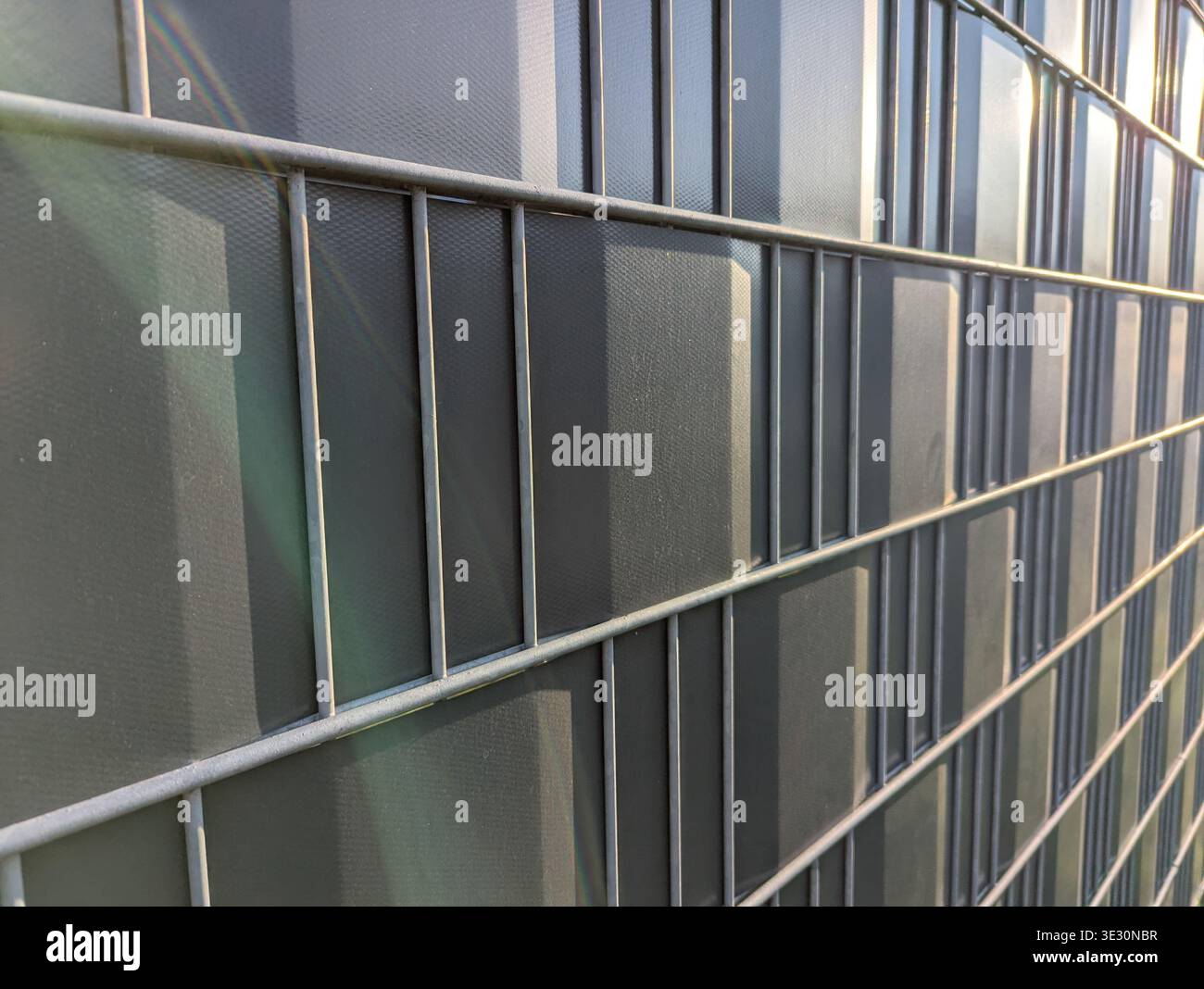 Reflektierende Glasfliesen Fassadeneinfanglicht, rhythmisches Gitter aus mattierten und klaren Panels mit dezenten grünen Reflektionen Nahtbereich betont Nähte, T Stockfoto