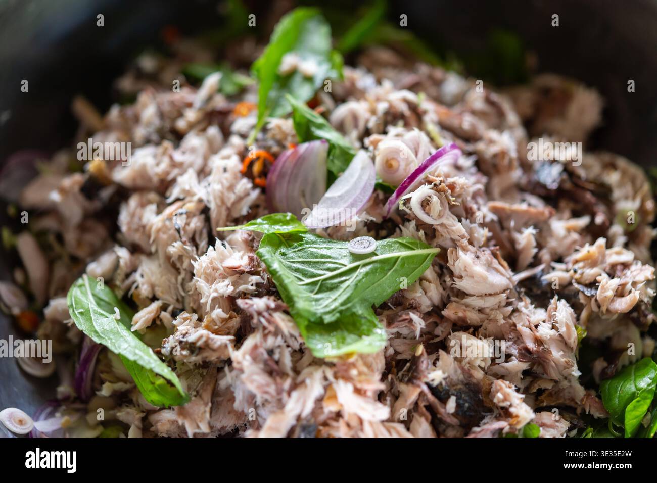 Würziger Thai Makrelen-Salat gemischt mit frischen Kräutern Schalotte und Chili für eine kräftige Geschmacksstruktur und authentischen asiatischen Street Food-Geschmack mit lebendigem n Stockfoto