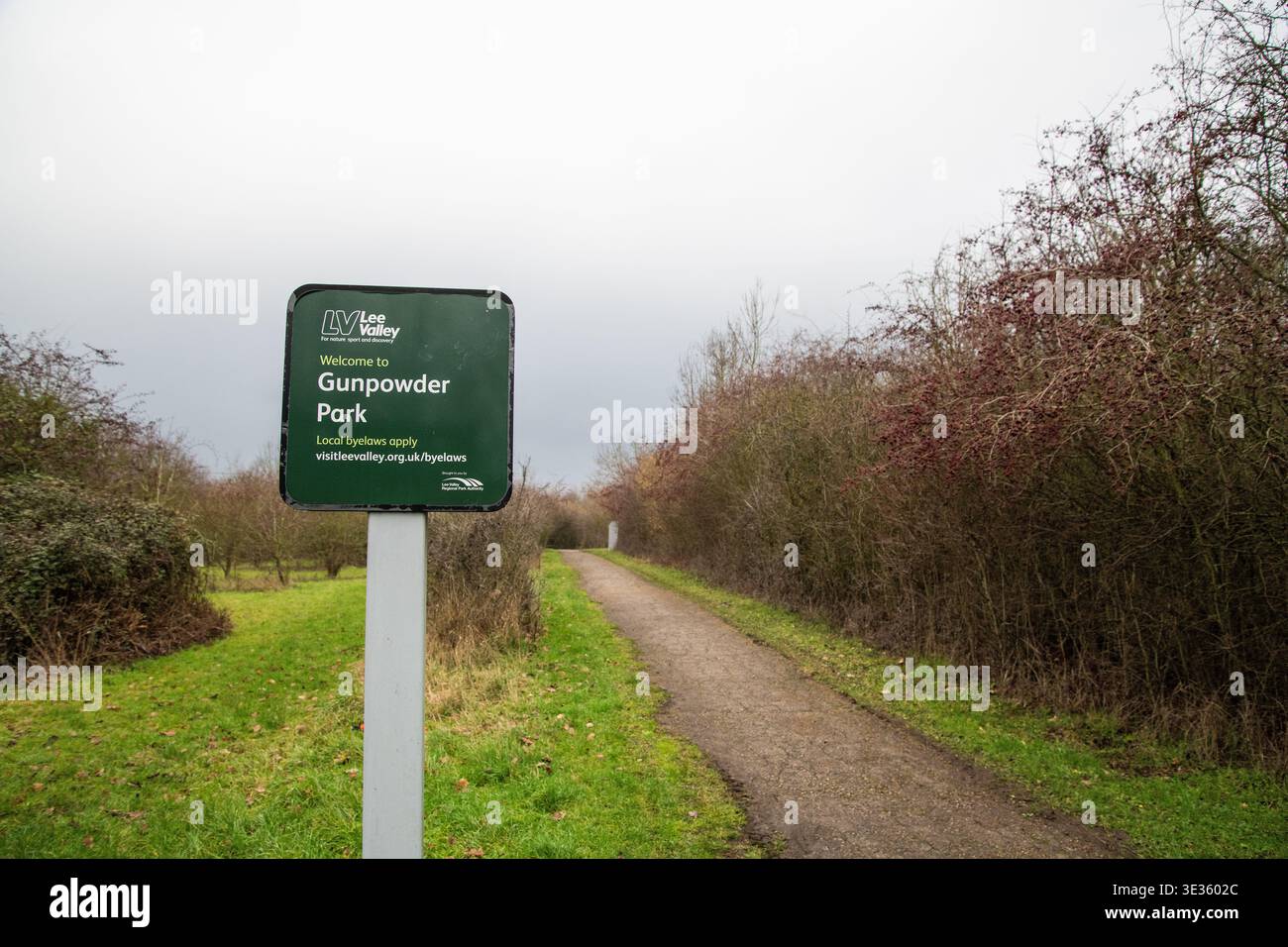 Foto des „Welcome to Gunpowder Park“-Schildes entlang eines Fußwegs und einer Brücke, das den Eingang zum Park und den Erholungsbereich im Freien hervorhebt. Stockfoto