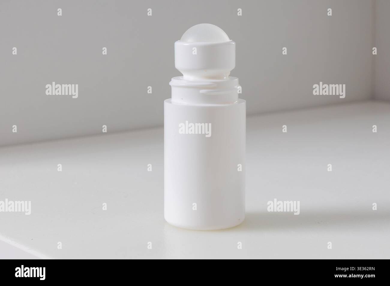 Eine einfache weiße Flasche mit Roll-on-Design, isoliert auf einem sauberen weißen Hintergrund, was eine minimalistische Produktpräsentation suggeriert. Stockfoto