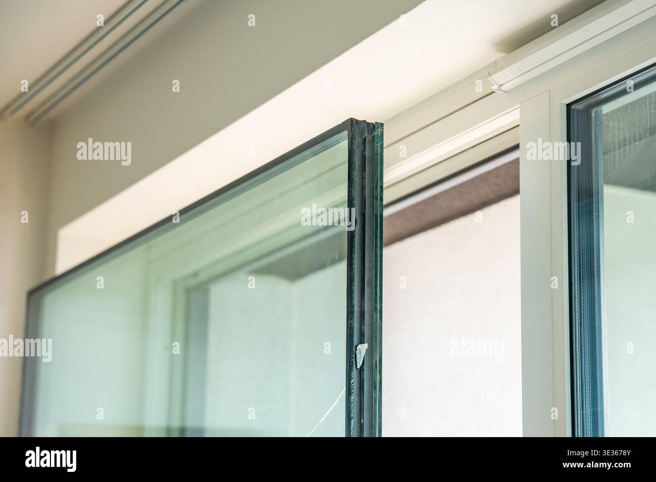 Die dreifach verglaste Glaseinheit wurde nach dem Austausch in der Wohnung in der Nähe des Rahmens entfernt. Entfernen und Reparieren der defekten Isolierglasscheibe Stockfoto