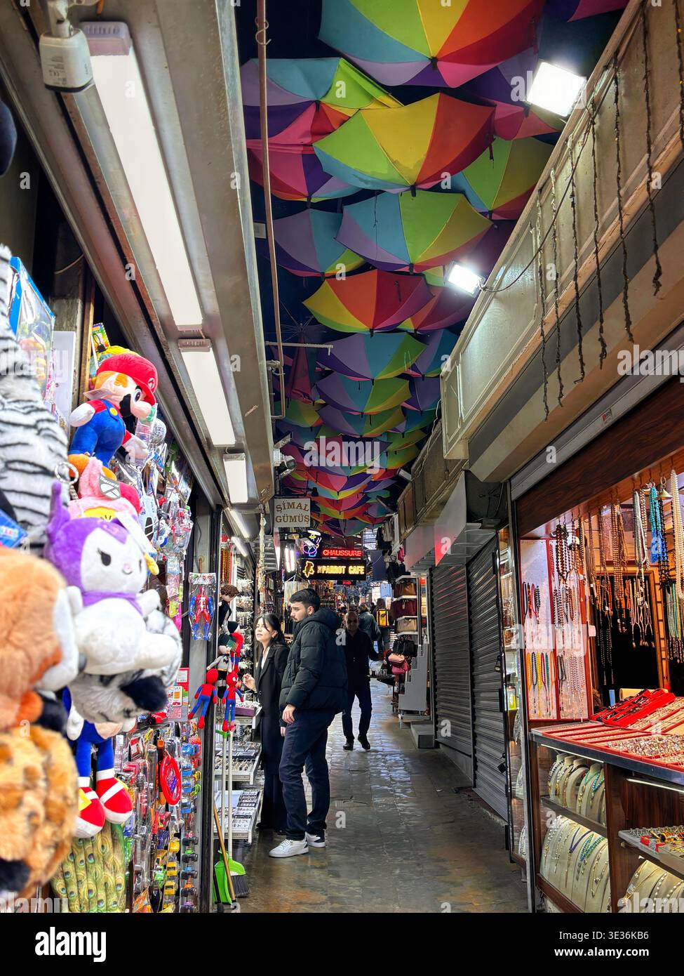 Lebhafte enge Straßenszene in İstiklal – bunte Sonnenschirme, geschäftige Geschäfte, Händler und gemütliche Restaurants schaffen eine lebendige urbane Atmosphäre.10 Marc. Stockfoto
