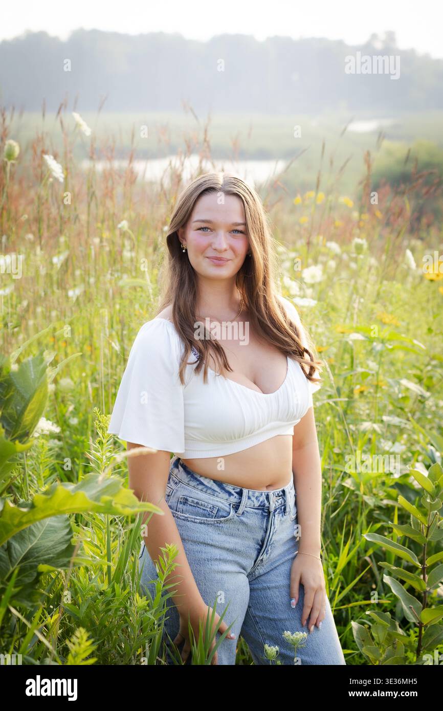 High School Senior Porträt in Wildblumen Mädchen im lässigen Denim Look Stockfoto