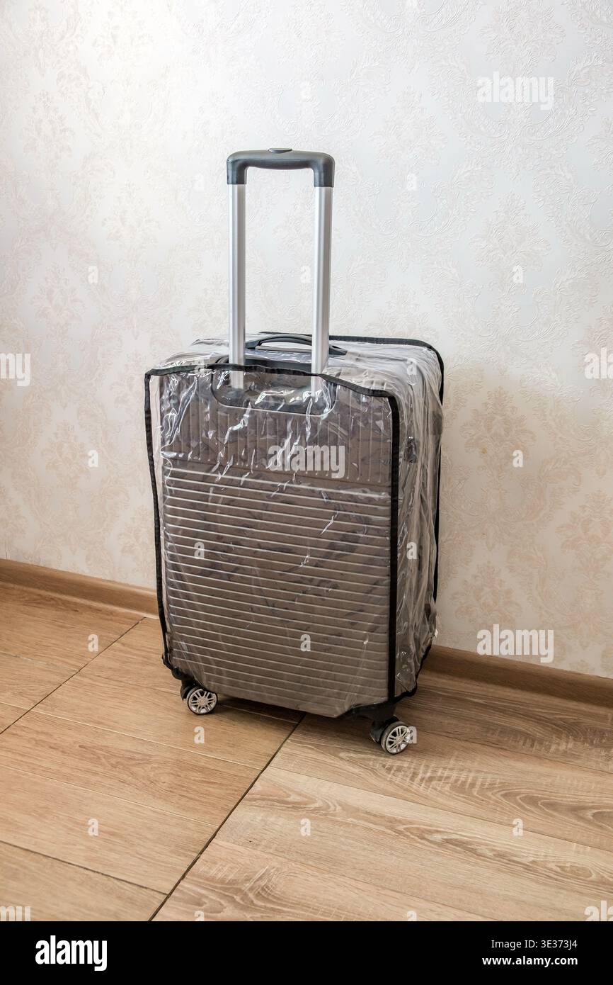 Koffer auf Rädern auf dem Boden im Zimmer Stockfoto