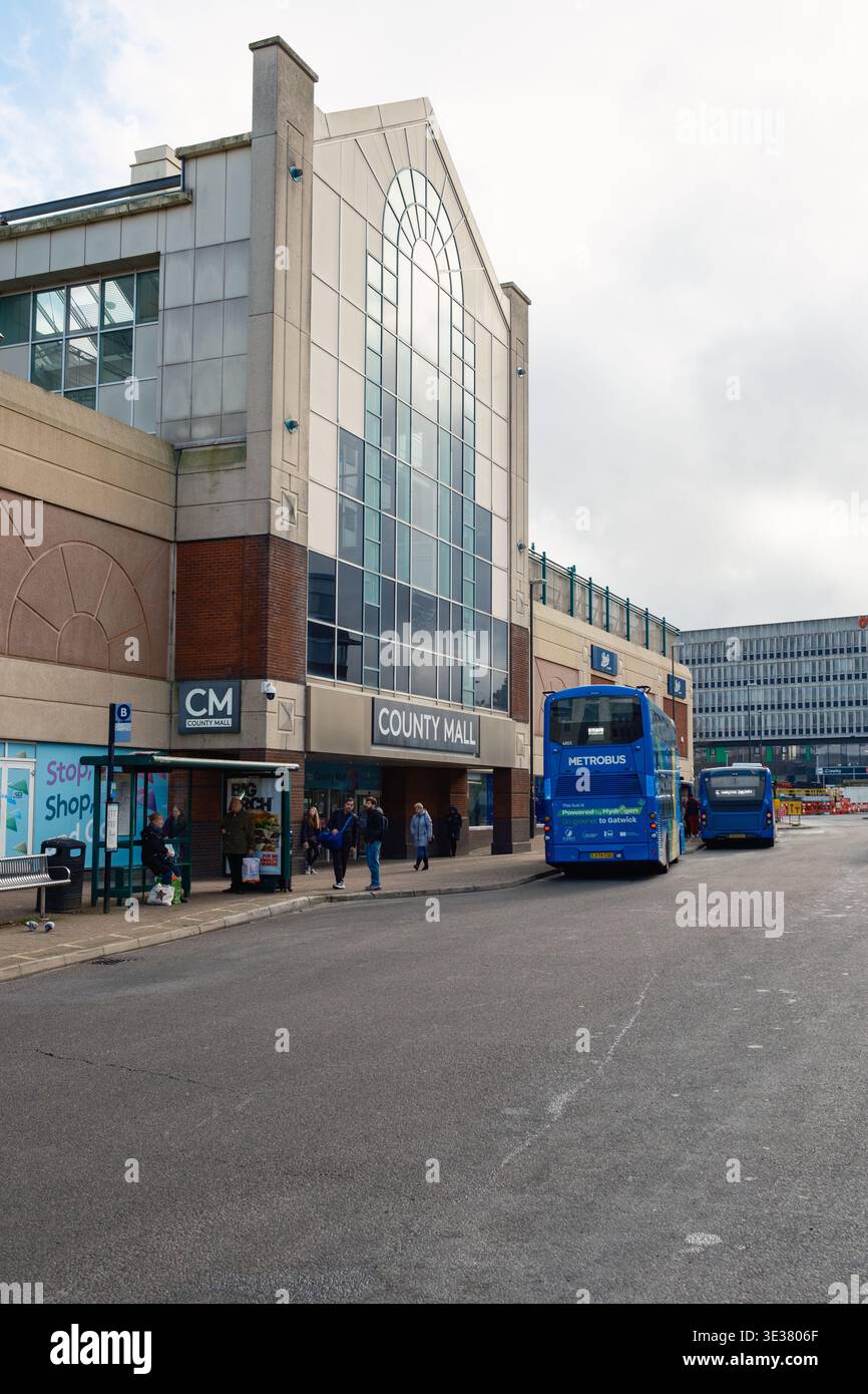 Bushaltestelle der County Mall in Crawley England mit Bussen und dem Einkaufszentrum mit Glasfassade in Schuss. Stockfoto