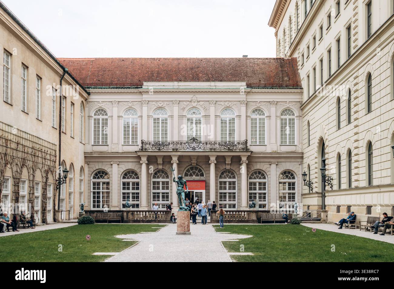 München, Deutschland - 15. April 2025: Innenhof der Münchner Residenz mit klassischer Fassade, Bogenfenstern, zentraler Statue und symmetrischem Gartenaufbau Stockfoto