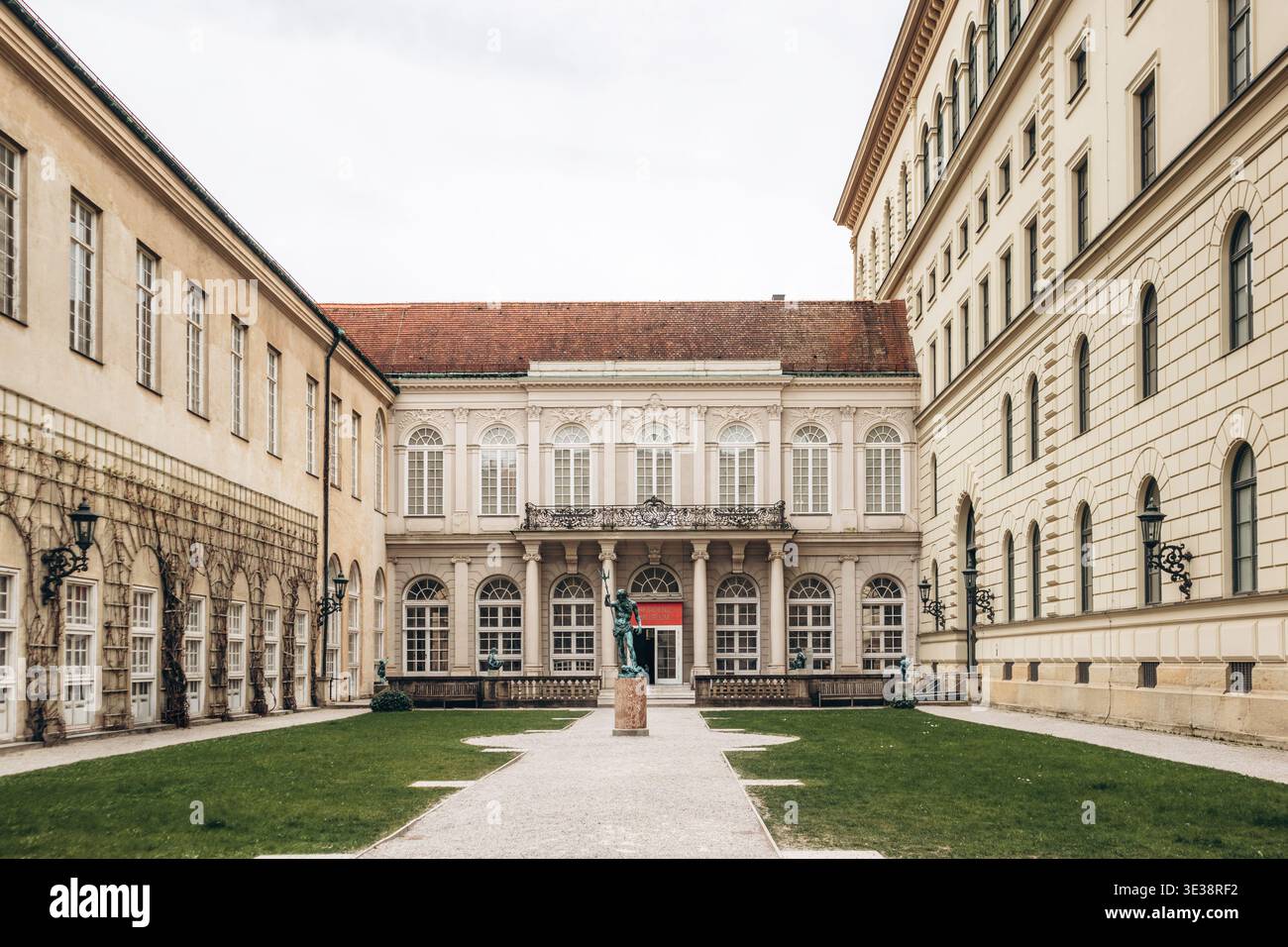 München, Deutschland - 15. April 2025: Innenhof der Münchner Residenz mit klassischer Fassade, Bogenfenstern, zentraler Statue und symmetrischem Gartenaufbau Stockfoto