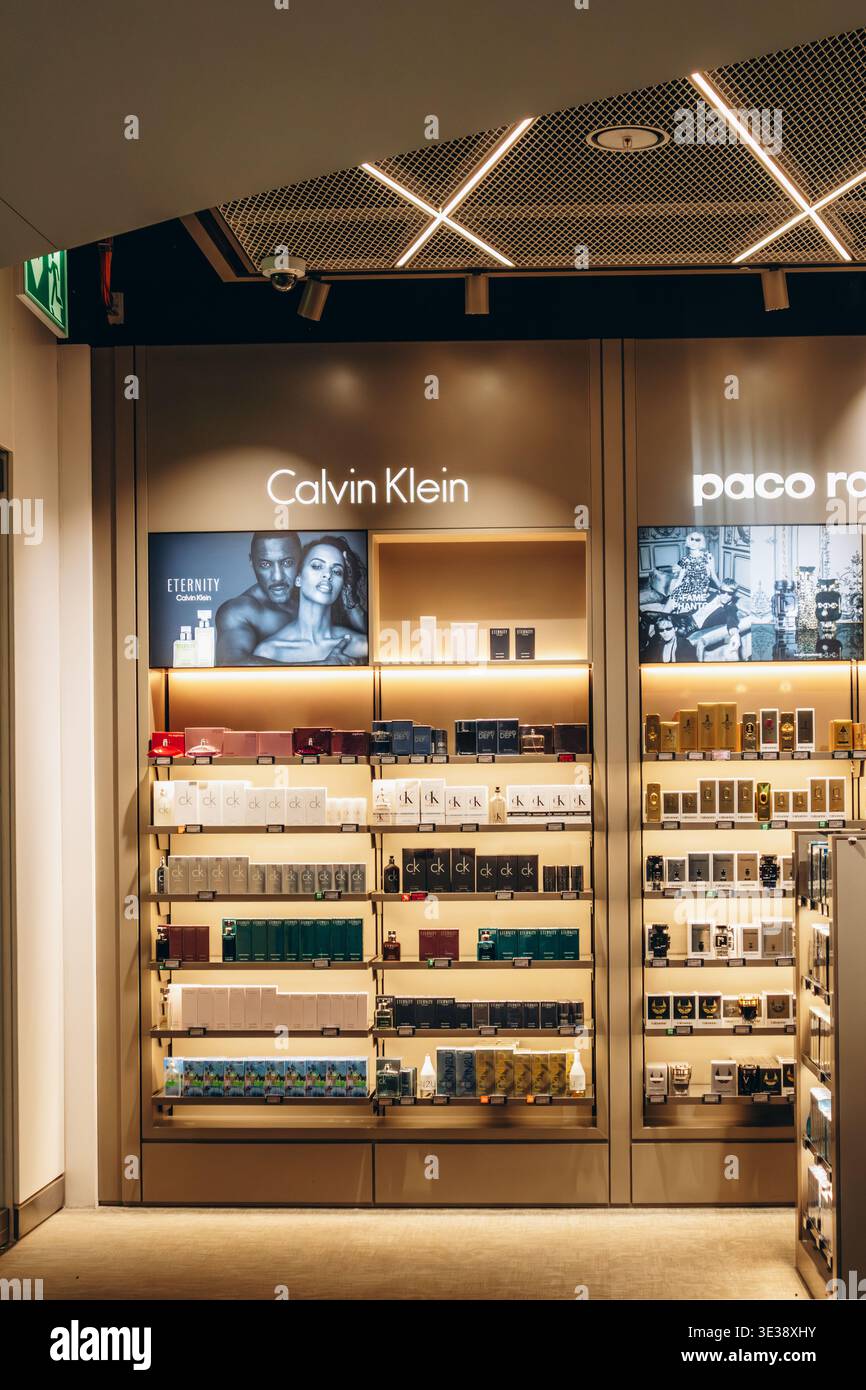 München, Deutschland - 15. April 2025: Calvin Klein Duftausstellung im Duty-Free-Geschäft am Flughafen München mit beleuchteten Regalen und organisiertem Produkt Stockfoto