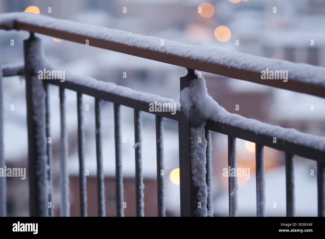 Schnee bedeckt ein Balkongeländer in einer Stadt im Winter Stockfoto