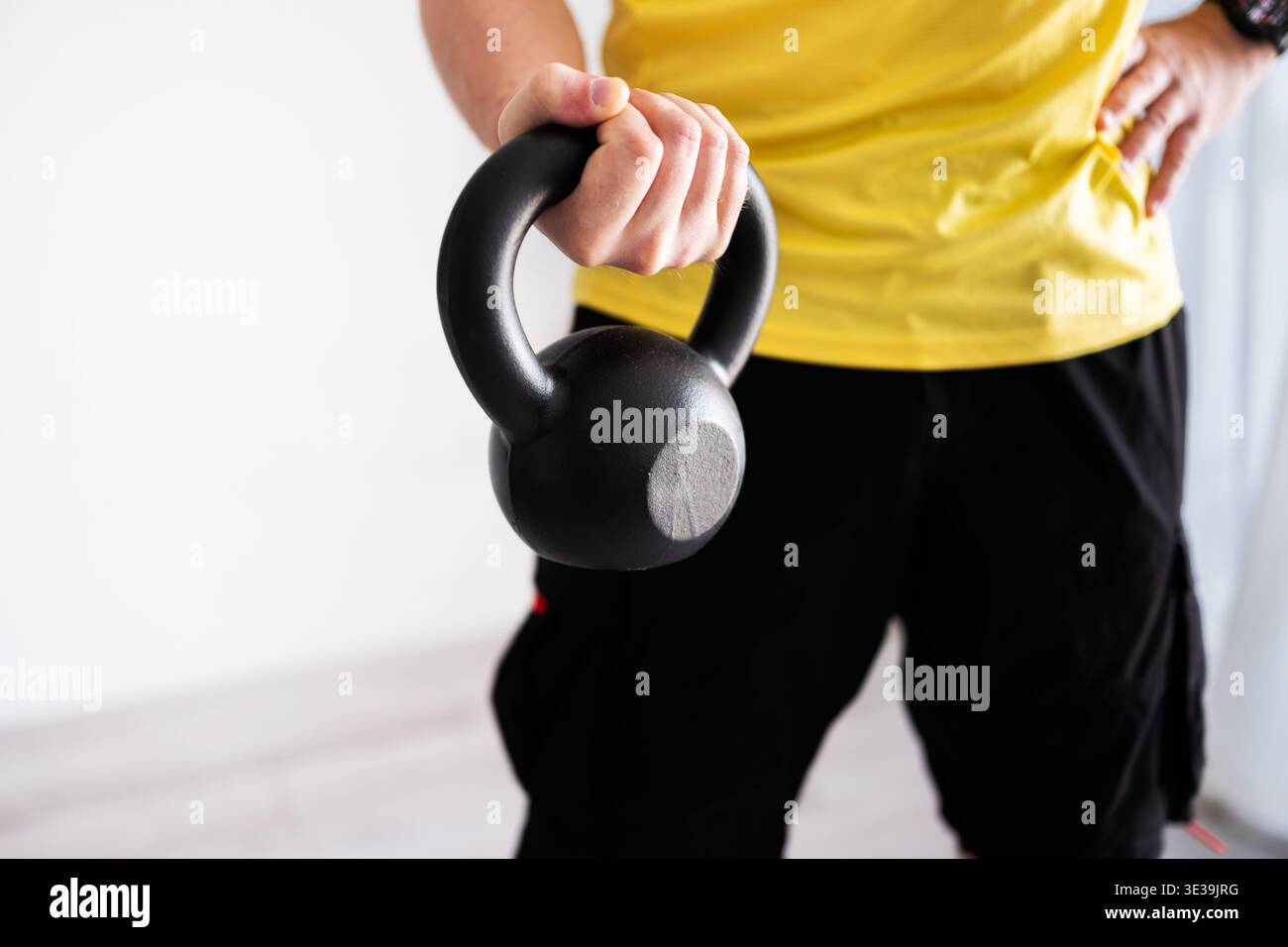 Sportlicher Mann Beim Arm- Und Schultertraining Mit Kurzhanteln Zu Hause Stockfoto