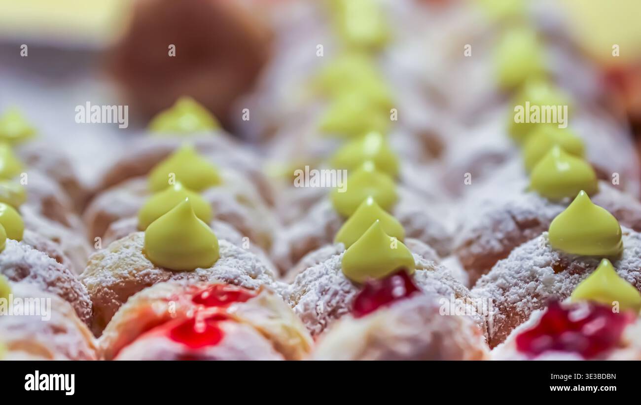 Hausgemachte Vanilledughnüsse mit Sahne und Puderzucker. Eine lebendige Präsentation von Fusionssüßen von einem thailändischen Straßenmarkt, ideal für Food-Editorials. Stockfoto