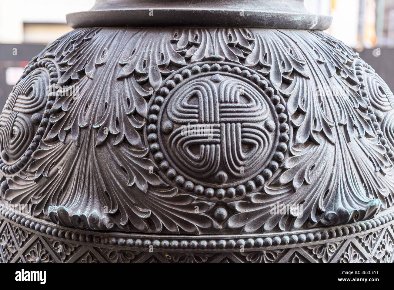 Die verzierte Metallbasis zeigt ein kreisförmiges Motiv in der Mitte, umgeben von komplizierten Blattmustern und dekorativen Perlen. Stockfoto