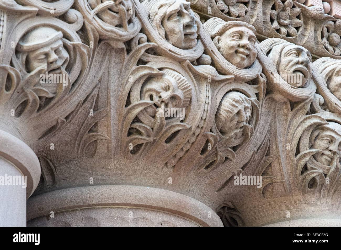 Komplizierte Steinschnitzereien zeigen ausdrucksstarke menschliche Gesichter, die mit dekorativen organischen Mustern auf architektonischen Säulen verwoben sind. Detail des Old City Ha Stockfoto