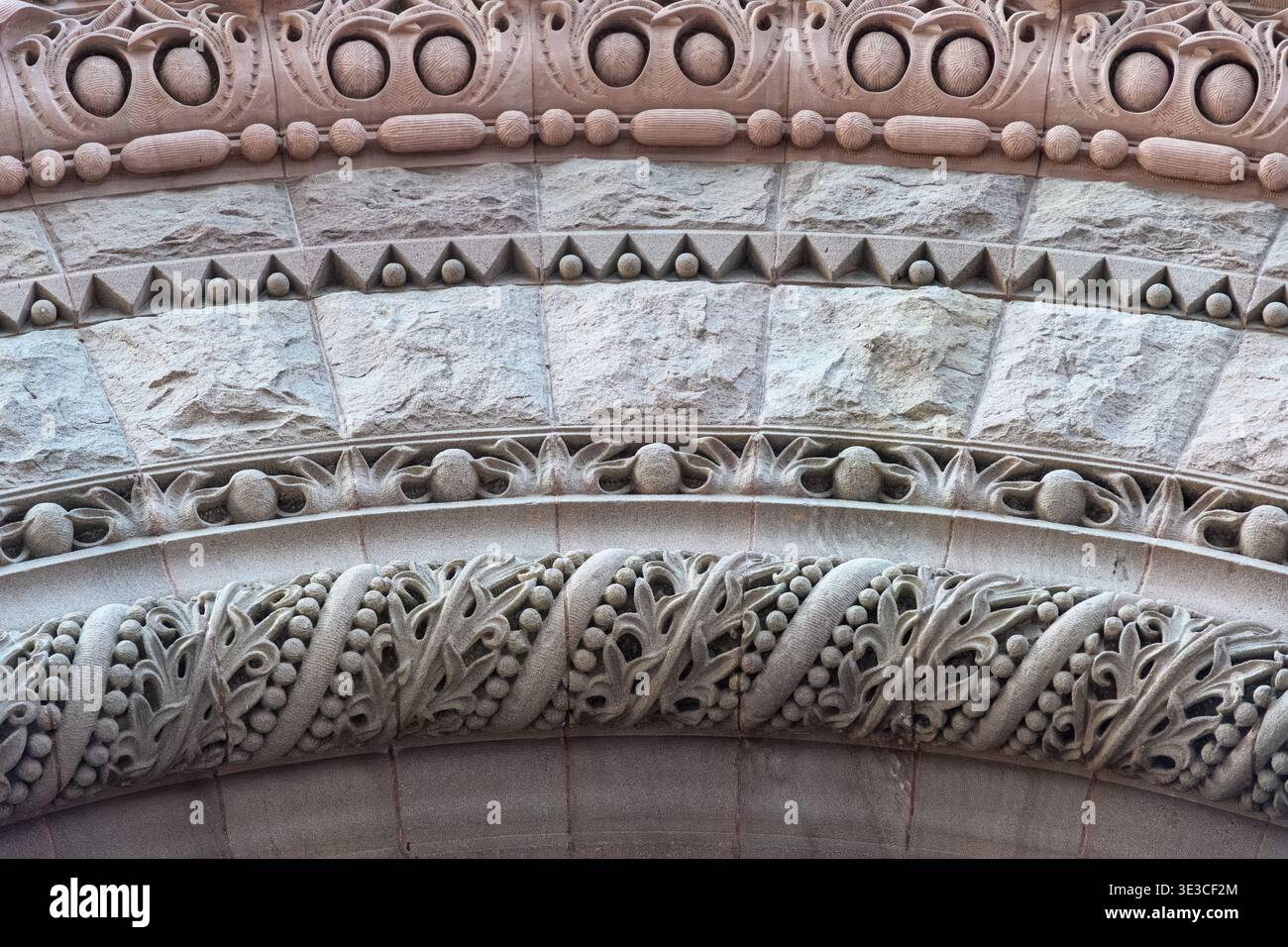 Der kunstvoll verzierte Steinbogen verfügt über mehrschichtige dekorative Bänder mit geometrischen Formen, geschnitzte Obstgruppen und fließende Laubmuster. Details zur Altstadt Stockfoto