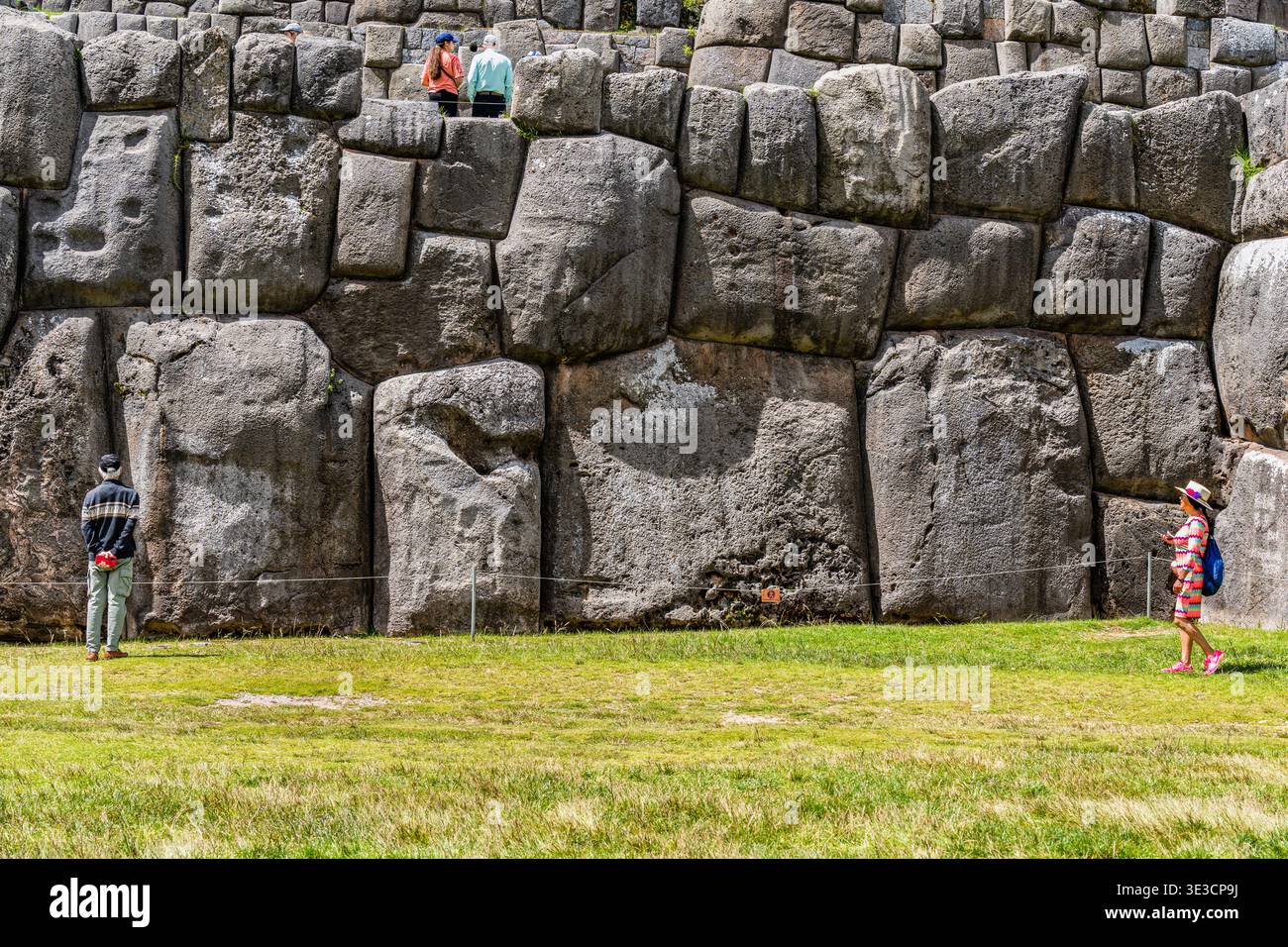 Cusco, Peru - 22. März 2025: Touristen, die sich die beeindruckenden megalithischen Steinmauern von Sacsayhuaman in Cusco, Peru, ansehen Stockfoto