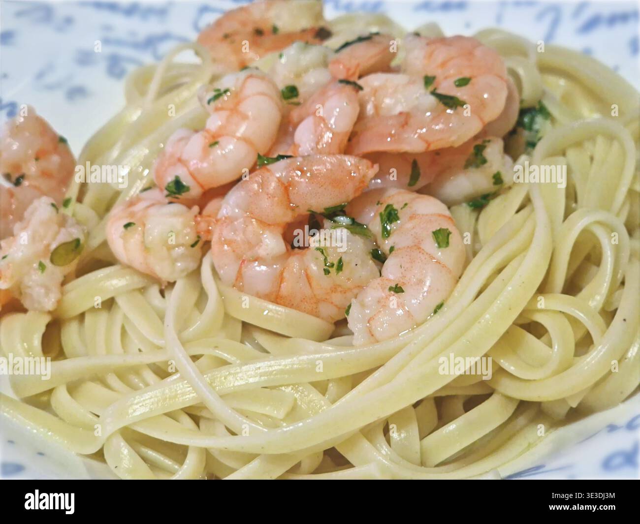 Köstliche Shrimps-Scampi-Linguine mit rosa Meeresfrüchten und grünen Kräutern Stockfoto