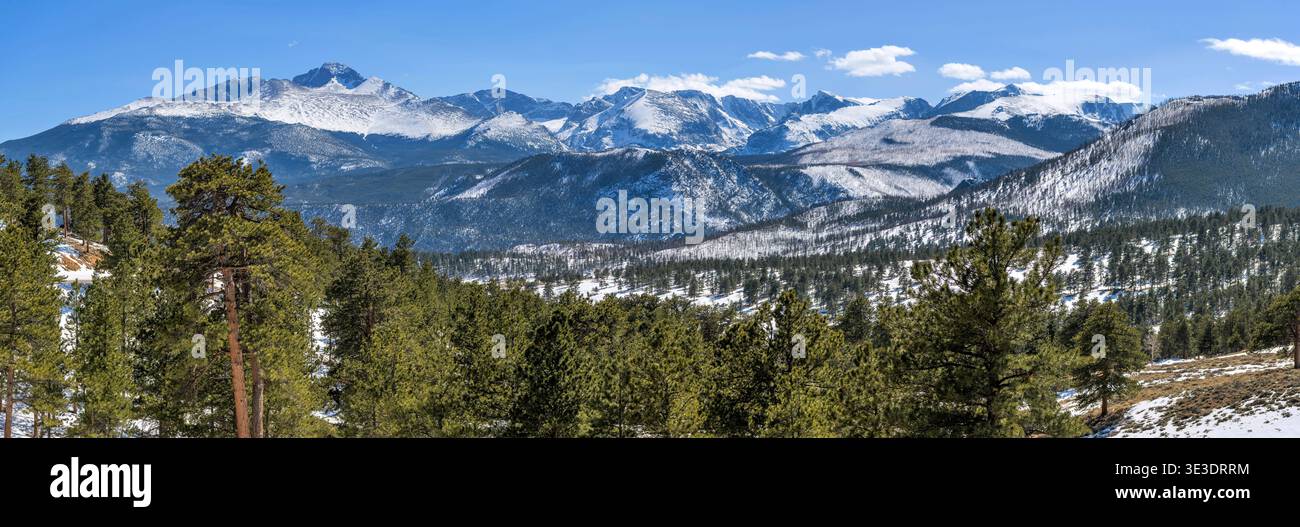 Rocky Mountain National Park - Panorama der schneebedeckten nördlichen Front Range Berge, die an einem sonnigen Frühlingstag links vom majestätischen Longs Peak geführt werden. Stockfoto