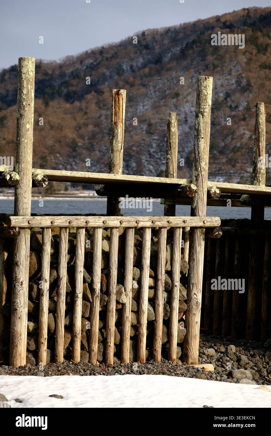 JAPAN - 7. FEBRUAR 2026: Nahaufnahme von verwittertem Holz und Flechten an einem traditionellen Pier am See Chuzenji, Nikko. Stockfoto