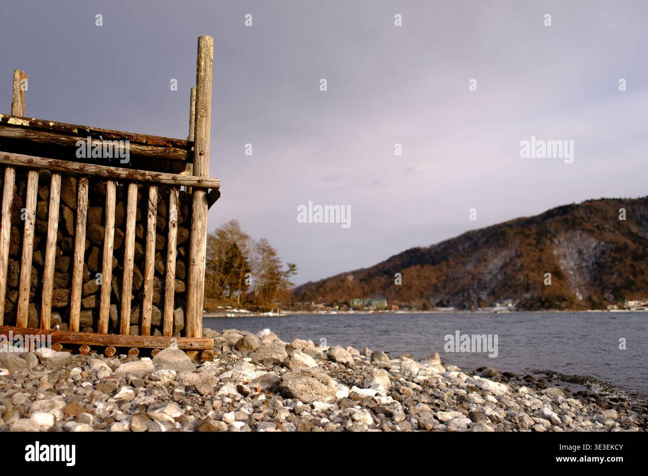 JAPAN - 7. FEBRUAR 2026: Die zerklüftete Küste des Lake Chuzenji mit einem traditionellen Holzsteg. Stockfoto