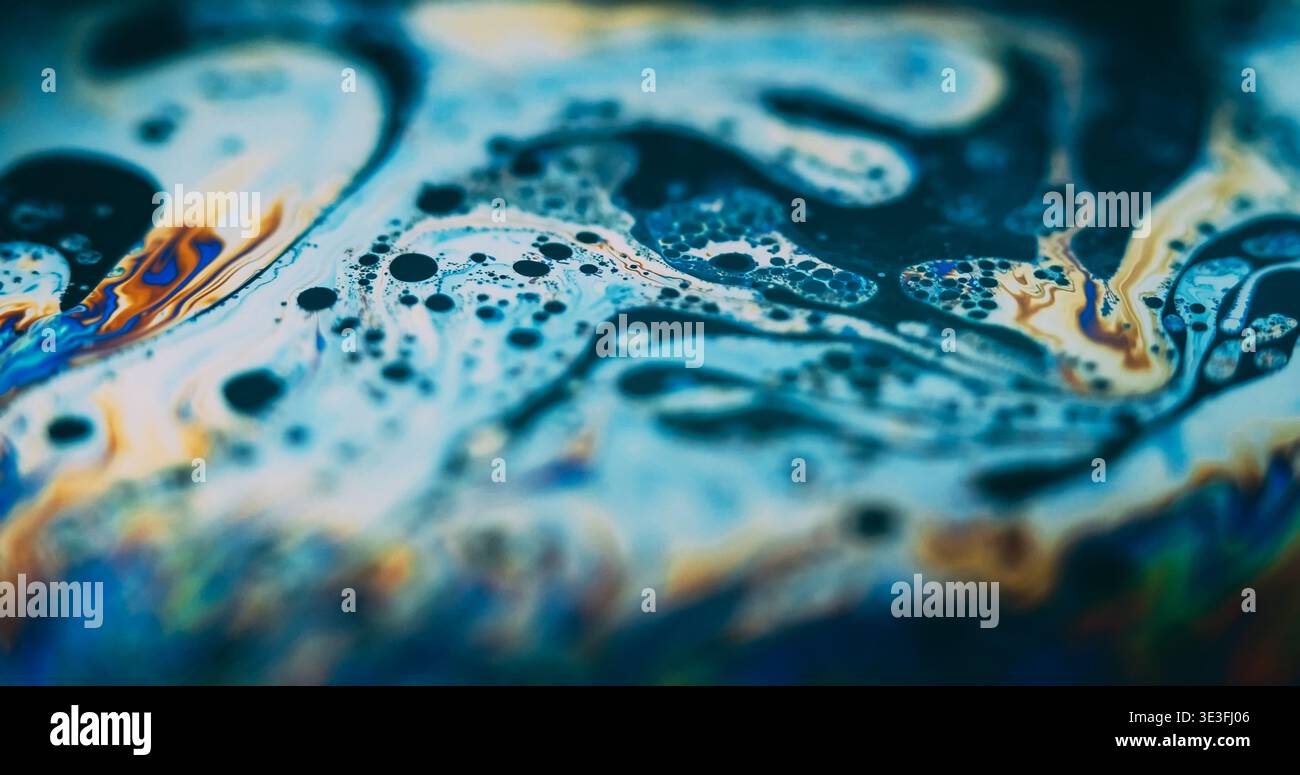 Ölblasen verfärben. Holografische Tinte. Defokussierte blaue orange gelbe Farbe Psychedelic Flow Benzin rund Treibstoff Tropfen auf abstraktem Hintergrund. Stockfoto