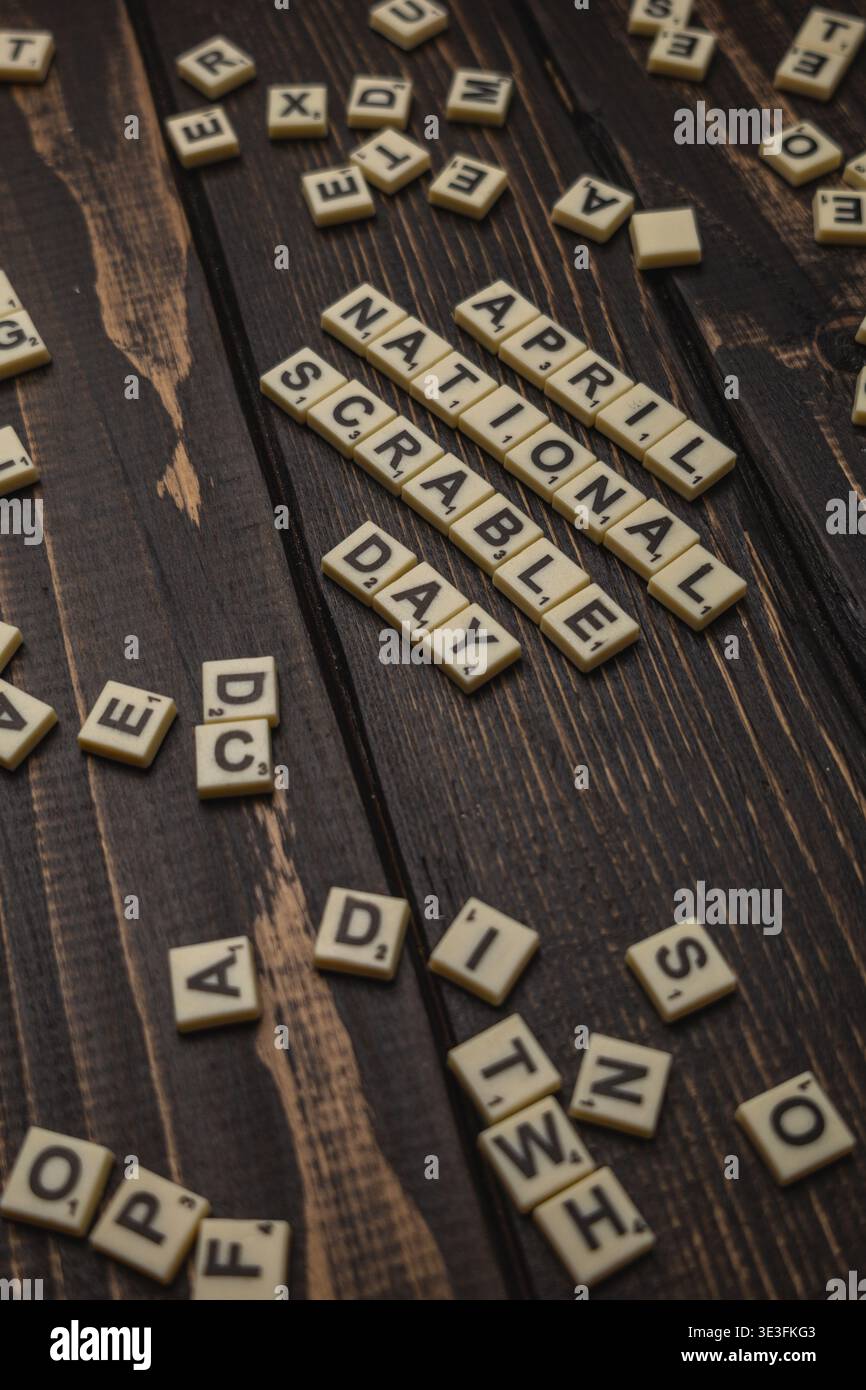 Lviv Ukraine 02.26.26 Fliesen beschriften den Nationalfeiertag im April auf einer hölzernen Oberfläche. Wörter sind verstreut und einige Buchstaben liegen in der Nähe. Stockfoto