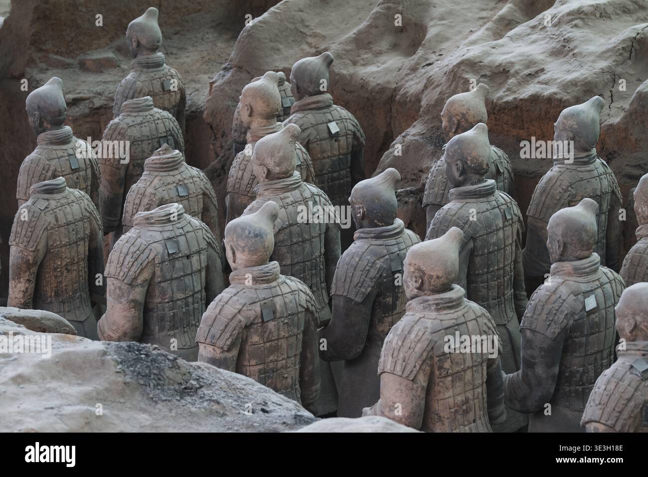 Blick auf Reihen von alten Terrakotta-Kriegern, die Schulter an Schulter stehen, ihre verwitterten Rüstungen und stoischen Ausdrücke gefroren in der Zeit, Xi'an, Shaanxi, CH Stockfoto