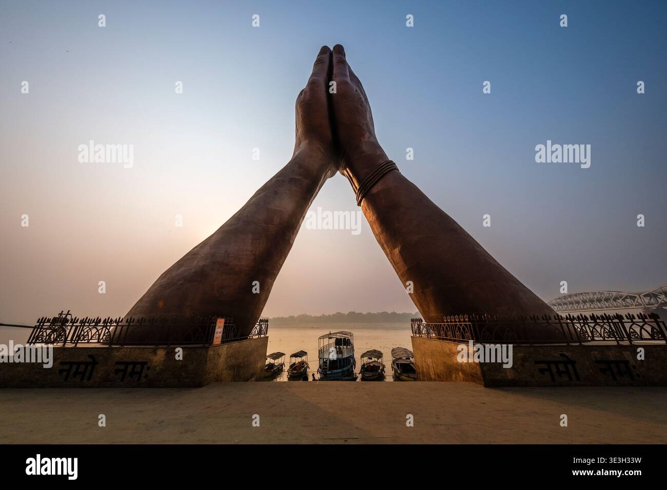 Die große Namo Mudra Skulptur thront über mehreren kleinen Booten, die bei Namo Ghat in Varanasi am Ufer des Ganges vertäut sind. Stockfoto
