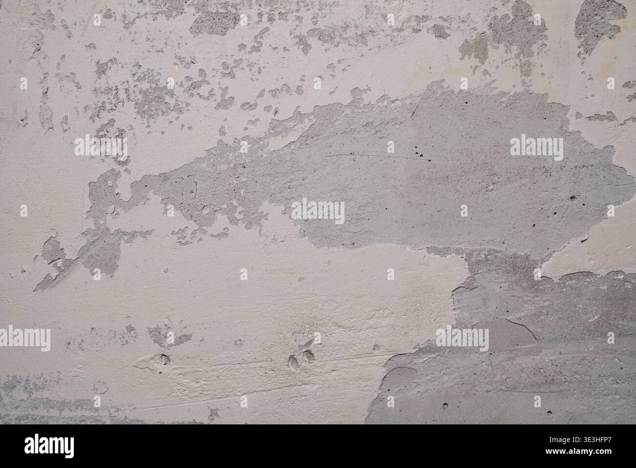 Strukturierte Wandoberfläche mit abziehender Farbe und freiliegenden Materialschichten in neutralen Tönen Stockfoto