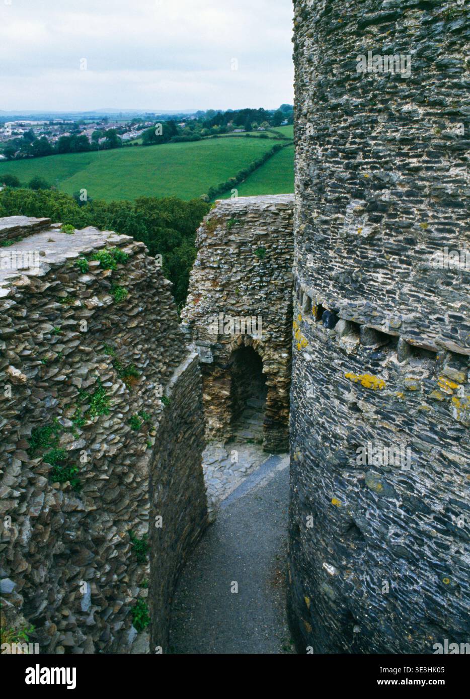Sehen Sie WSW von der C12th Shell Keep Mauer von Launceston Castle, Cornwall, England, Großbritannien, mit dem Eingang (L), der Treppe und dem C13th Central Round Tower. Stockfoto
