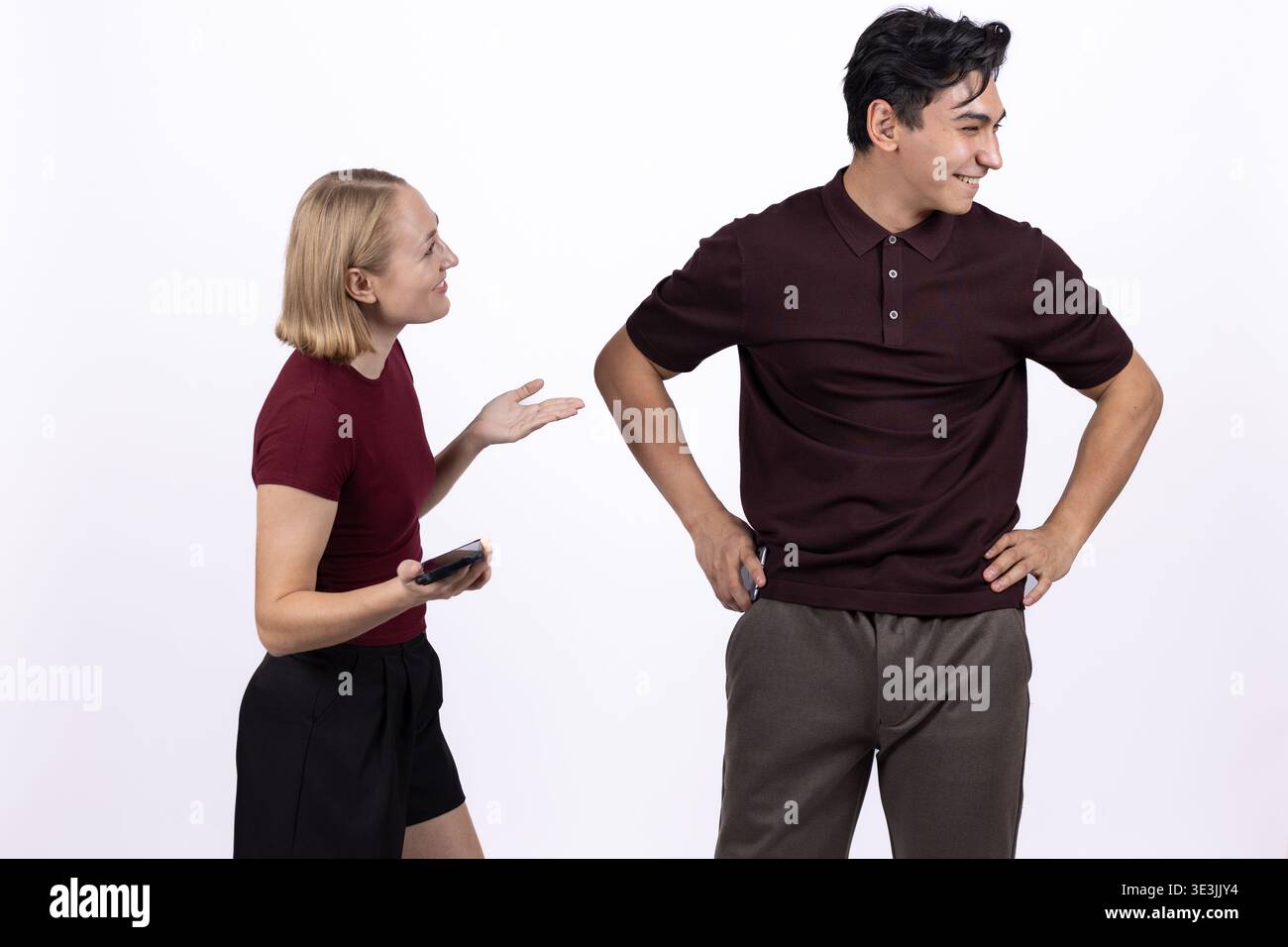 Eine junge Frau, die mit einem Mann spricht, der in einem Studio wegschaut Stockfoto