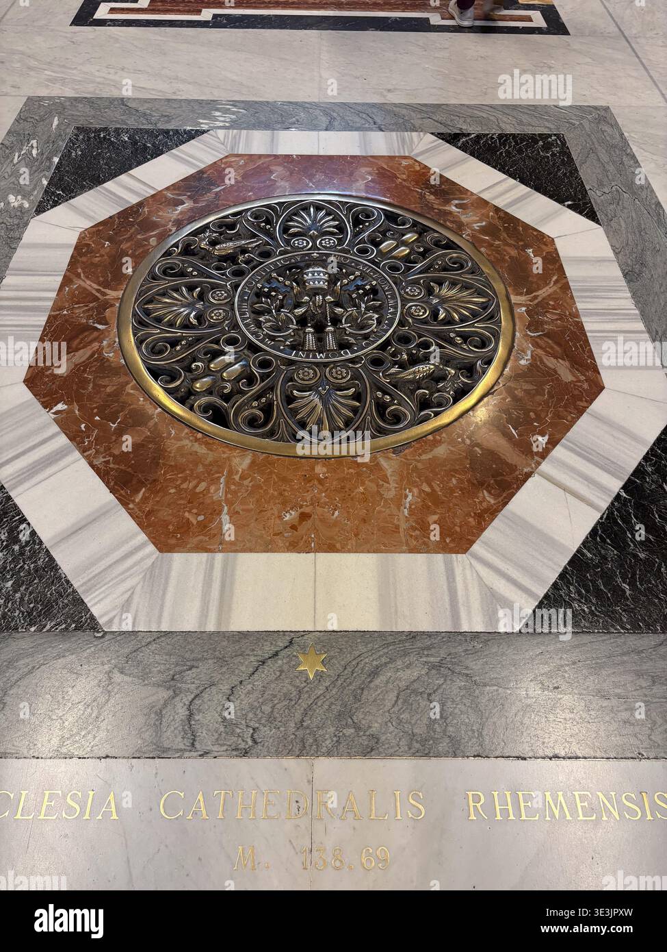 Basilica di San Pietro Bodendetail mit einem bronzenen päpstlichen Wappenmedaillon aus mehrfarbigem Marmor, Vatikanstadt. Stockfoto