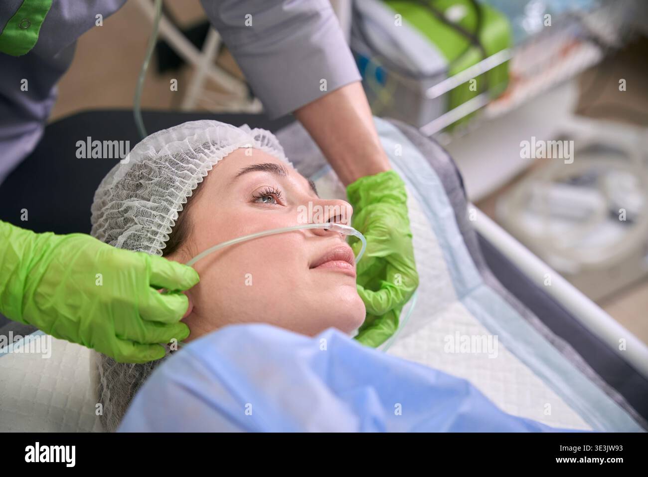 Ruhige Patientin mit Sauerstoffkanüle in der medizinischen Einrichtung Stockfoto