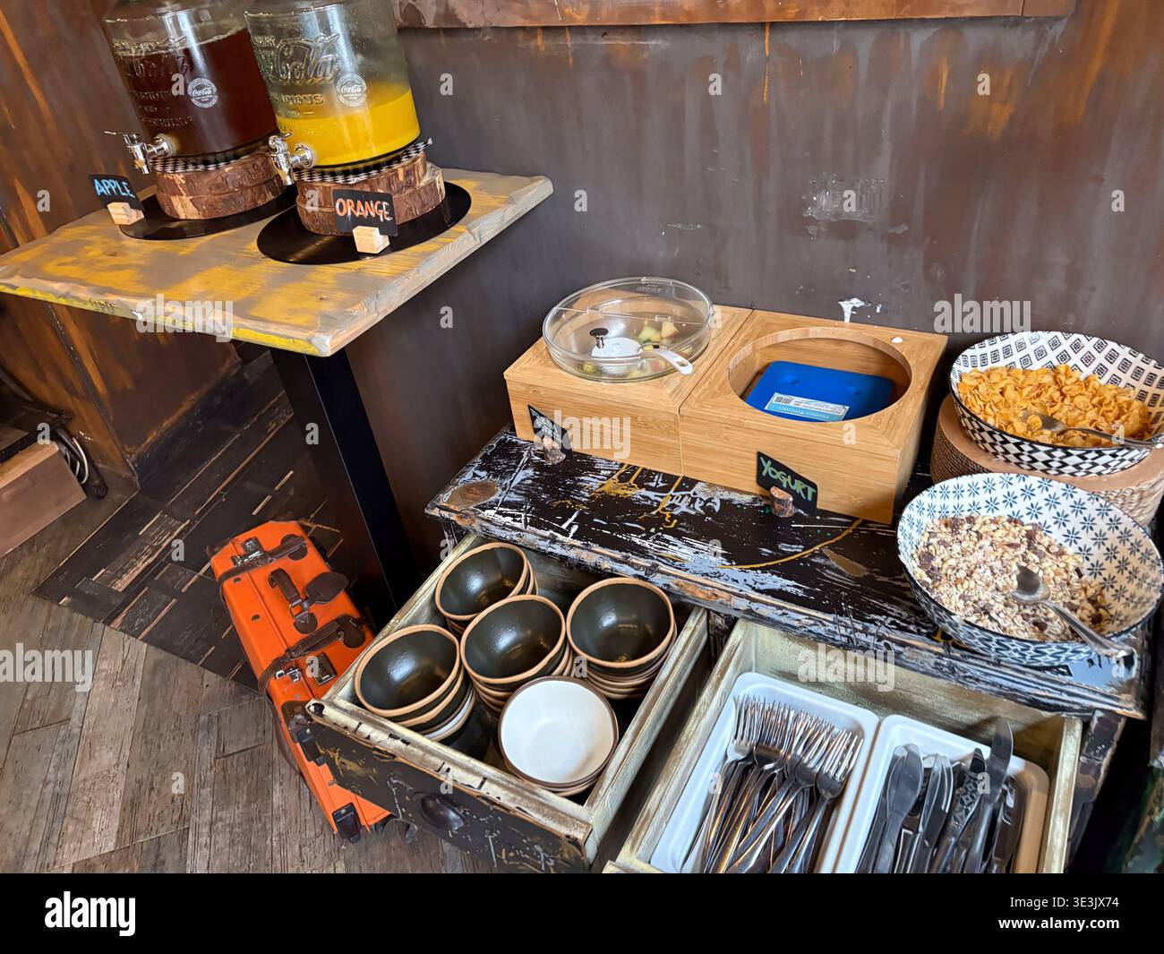 Das Frühstücksbuffet des Hotels in Rom, Italien, bietet rustikale Speisen mit Saftspendern, Müslischalen und Besteck. Stockfoto