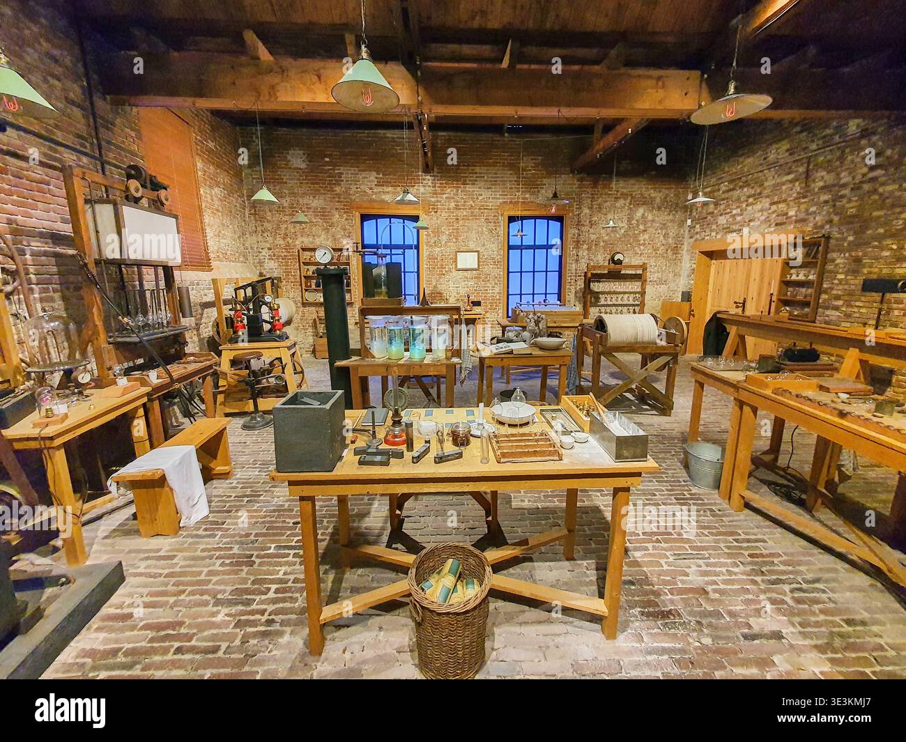 Innenraum eines historischen wissenschaftlichen Labors oder einer Werkstatt mit freiliegenden Ziegelwänden und -Böden, Holzbalken und Vintage-Ausstattung. Stockfoto