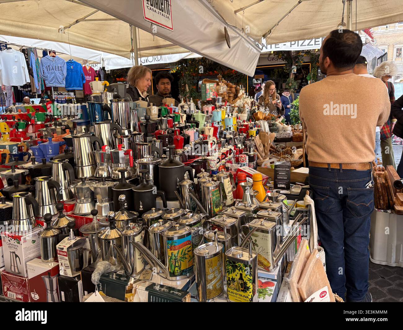 Moka Pots Stand am Campo de' Fiori Platz. Rom, Italien. Männer stöbern in italienischen Kaffeemaschinen und Olivenöldosen. Stockfoto