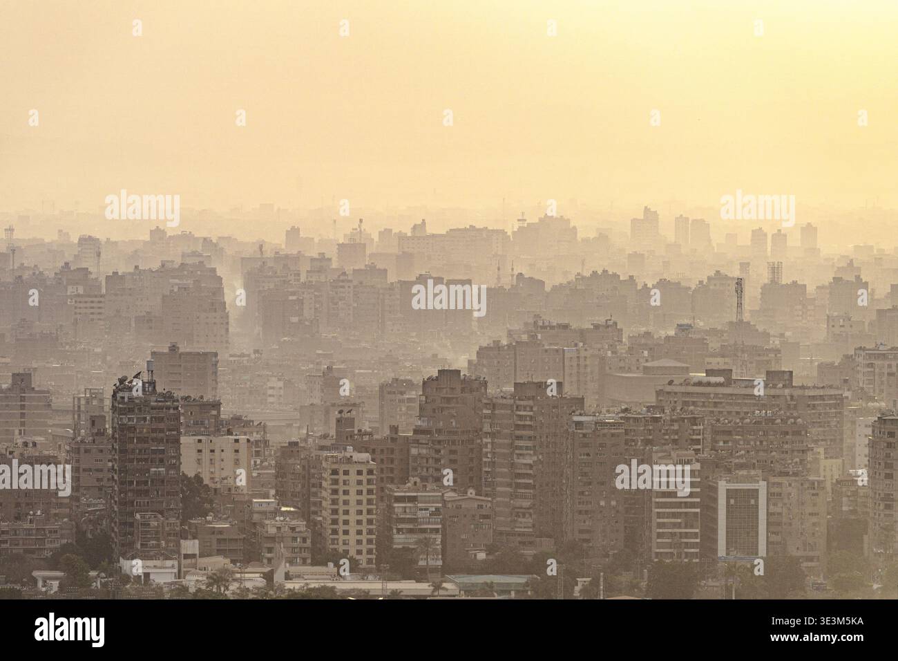 Blick auf eine trübe Metropole, wo Gebäude in einen weichen, sonnendurchfluteten Horizont versinken und eine ätherische Stadtlandschaft schaffen, Kairo, Gouvernement Kairo, Ägypten. Stockfoto
