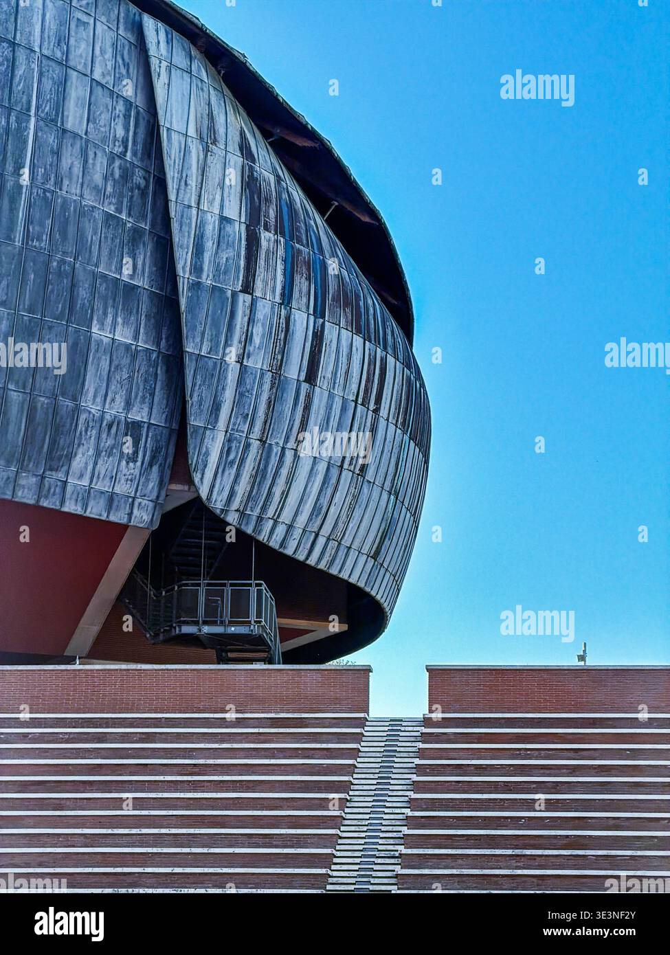 Das brutalistische Äußere eines der Gebäude des Parco della Musica Gebäudekomplexes in Rom steht über einem Sitzbereich im Freien. Stockfoto