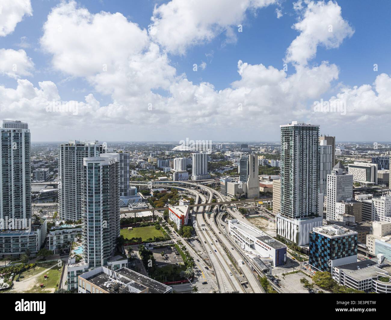 Blick aus der Vogelperspektive auf Wolkenkratzer, die die Skyline über dem pulsierenden Viertel Brickell durchziehen, mit Straßen, die sich unter einem riesigen Himmel durch die Stadt schlängeln, Miami, Florida, Stockfoto