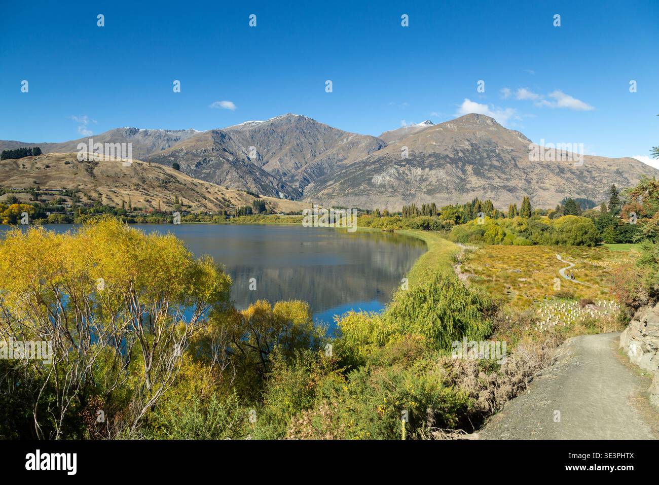 Blick über den Lake Hayes auf die Remarkables-Bergkette an einem hellen und sonnigen Apriltag, Central Otago, Neuseeland Stockfoto