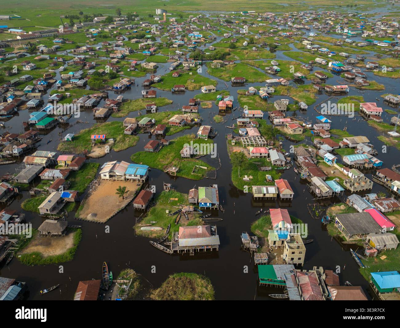 Aus dem Wasser ragen Stelzenhäuser aus der Vogelperspektive auf, die den Himmel in der Lagune reflektieren, ein Wandteppich des Lebens, das auf dem Wasser gewebt ist, Ganvié, Benin. Stockfoto
