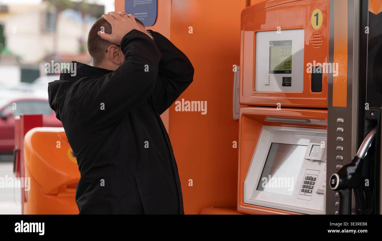 Gestresster Mann, der Leiter der Tankstelle hohe Kraftstoffpreise hält Stockfoto