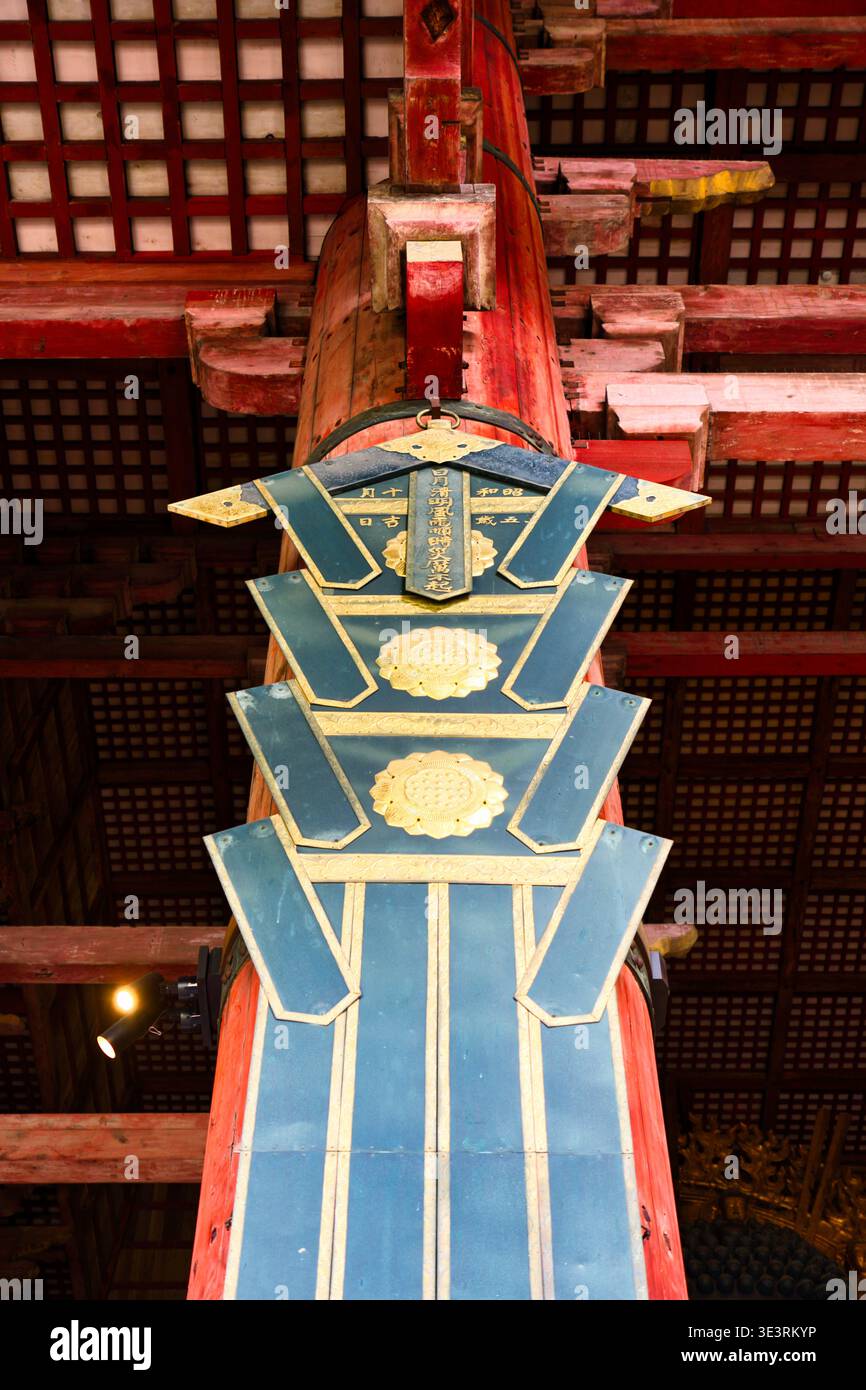 Vertikales hölzernes Schild neben der kleinen goldenen Buddha-Statue in der Daibutsuden Hall Nara Stockfoto