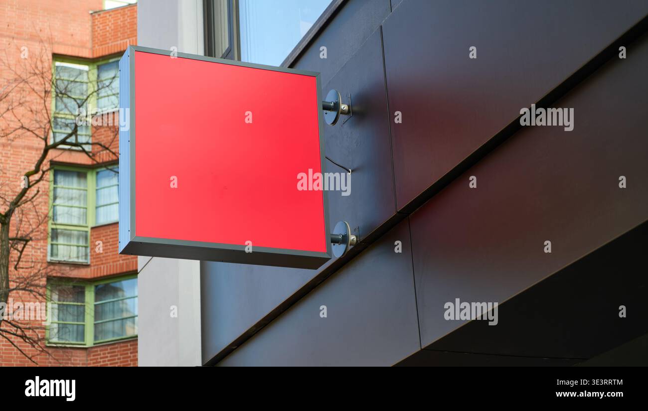 Eine Werbemockup-Vorlage mit leeren roten Schildern für Markenwerbung und Einzelhandel das leere Ladenschild ist auf der Außenwand angebracht Stockfoto