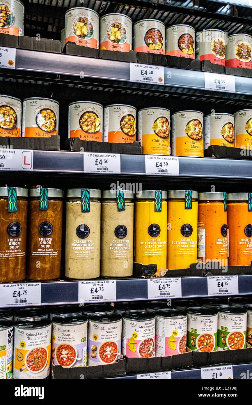 London, Großbritannien, 24. März 2026, Auswahl an beliebten Dosen und Gläsern mit Curry-Mahlzeiten und Suppen Convenience Food mit M&S-Markenzeichen Stockfoto