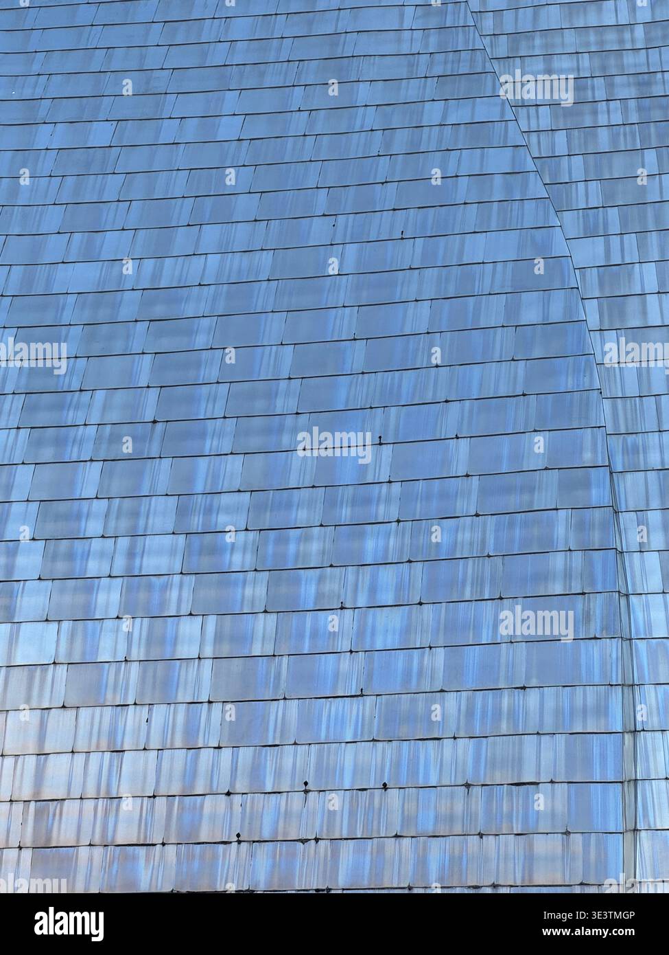 Abstrakte Nahaufnahme von Titanplatten mit geometrischem Muster und weichen Lichtverläufen. Moderne architektonische Textur mit reflektierender Oberfläche. - Smartphone-aufgenommenes Stockfoto