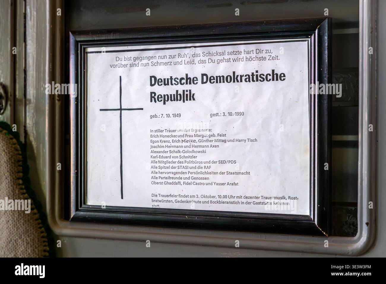Ein gerahmter satirischer Nachruf für die DDR (* 7. Oktober 1949, gestorben am 3. Oktober 1990) an der Wand eines DDR-Restaurants in Leipzig; Honecker, Mielke, Krenz und andere SED-Beamte sind als Trauer aufgeführt. Leipzig, Sachsen, Deutschland Stockfoto