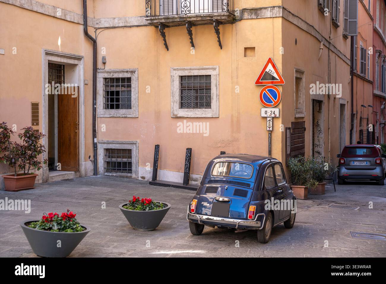 Ein klassischer, dunkelblauer Fiat 500, der entlang der mittelalterlichen Via Bartolo in der Nähe des Etruskerbogens im historischen Zentrum von Perugia, Umbrien, Italien, geparkt wird Stockfoto