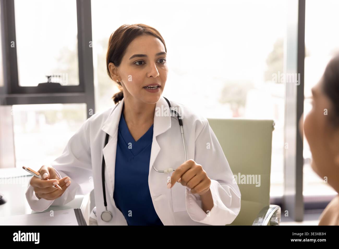 Der Arzt fragt nach Symptomen oder gesundheitlichen Bedenken an die Patientin Stockfoto