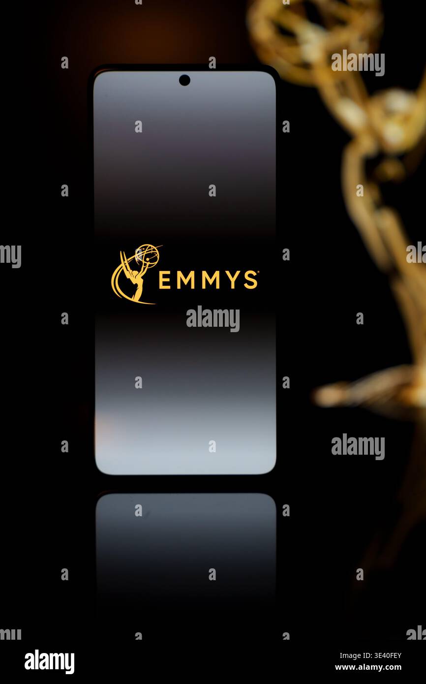 Emmys Logo auf einem Smartphone-Bildschirm mit einer verschwommenen Gold-Auszeichnung im Hintergrund, TV-Industrie-Auszeichnungen und Digital Streaming Co Stockfoto