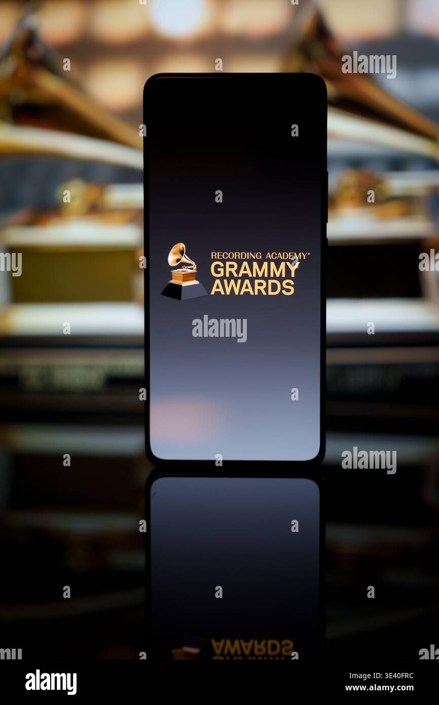 Grammy Awards-Logo auf einem Smartphone-Bildschirm mit verschwommenen goldenen Grammophon-Trophäen im Hintergrund, Auszeichnungen der Musikindustrie und digitaler Streami Stockfoto